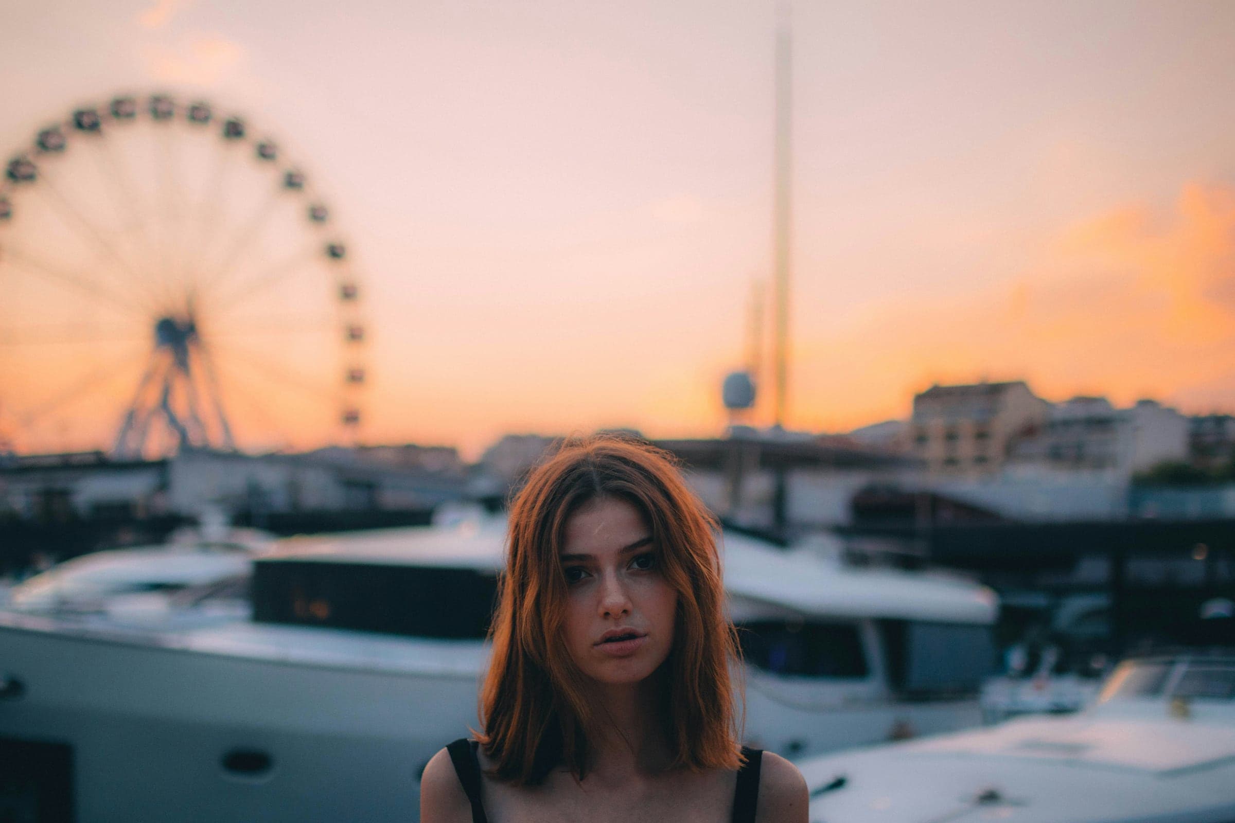 A portrait beside a marina in the soft pink light of sunset